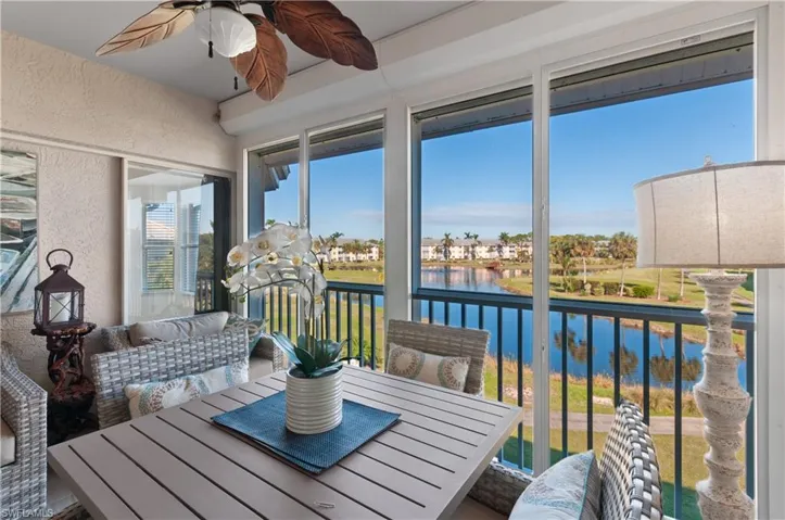 Sunroom / solarium with ceiling fan and a water view