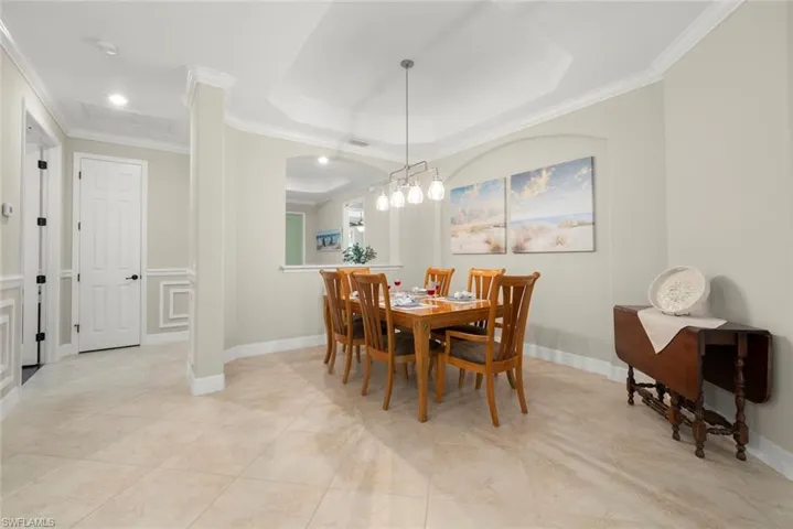 Dining area with tray ceiling with crown molding and new light fixture