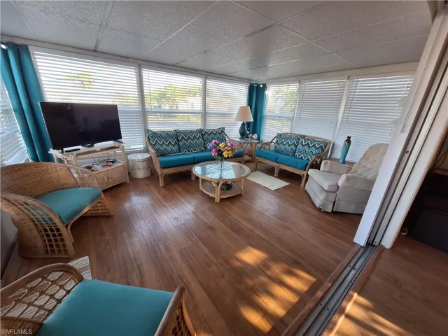 Living room featuring wood-type flooring and a paneled ceiling