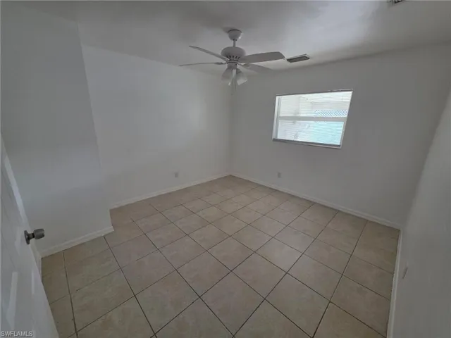 Unfurnished room with light tile patterned floors and ceiling fan