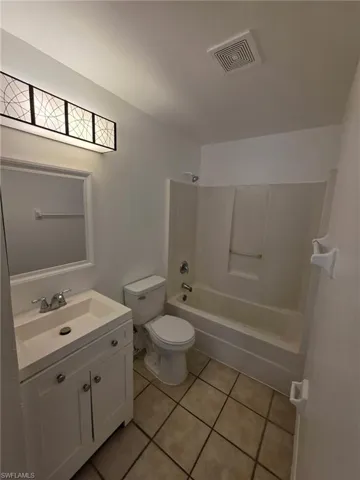 Full bath with vanity, shower / bathtub combination, and light tile patterned floors