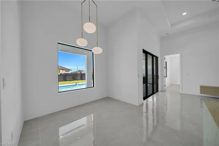 Unfurnished room featuring a towering ceiling and radiator heating unit