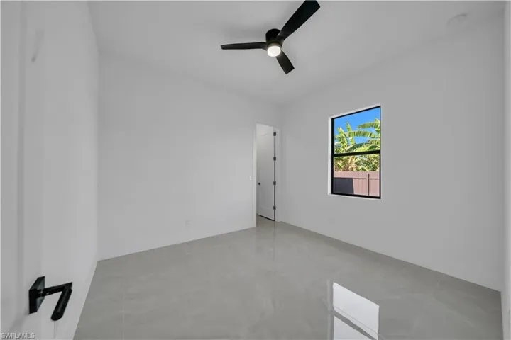 Empty room featuring a ceiling fan and baseboards
