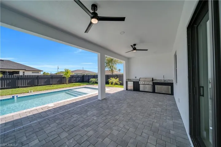 Fenced backyard with ceiling fan, a patio area, and a sink