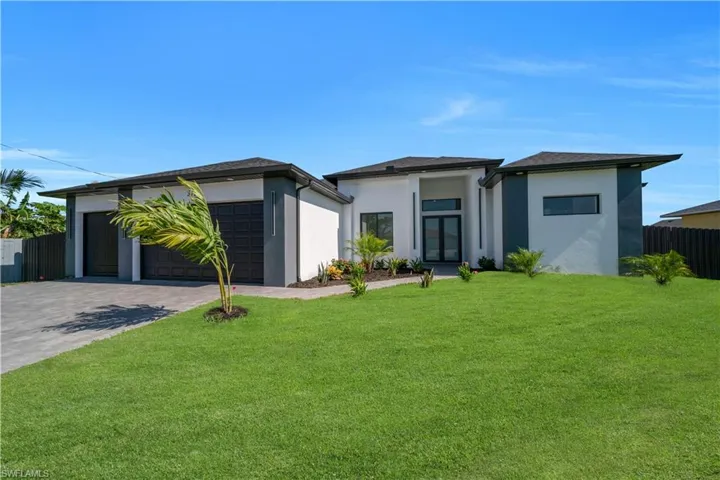 View of front of property with stucco siding, driveway, and an attached garage