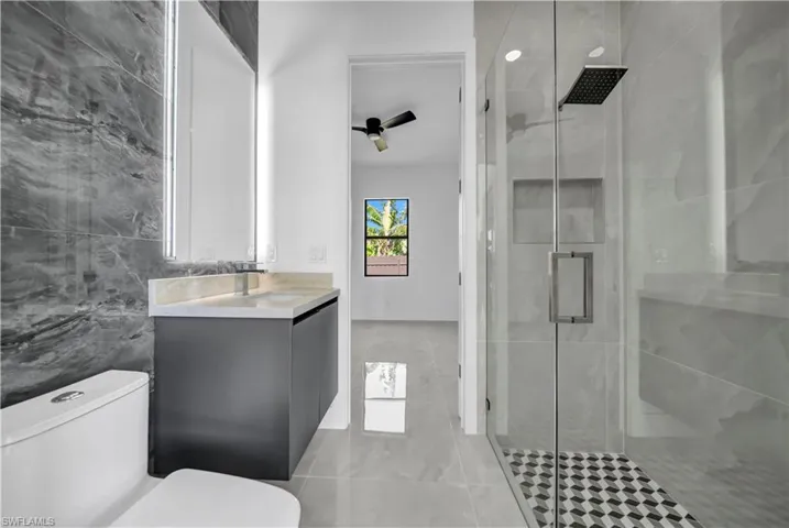 Full bathroom with vanity, a stall shower, and toilet