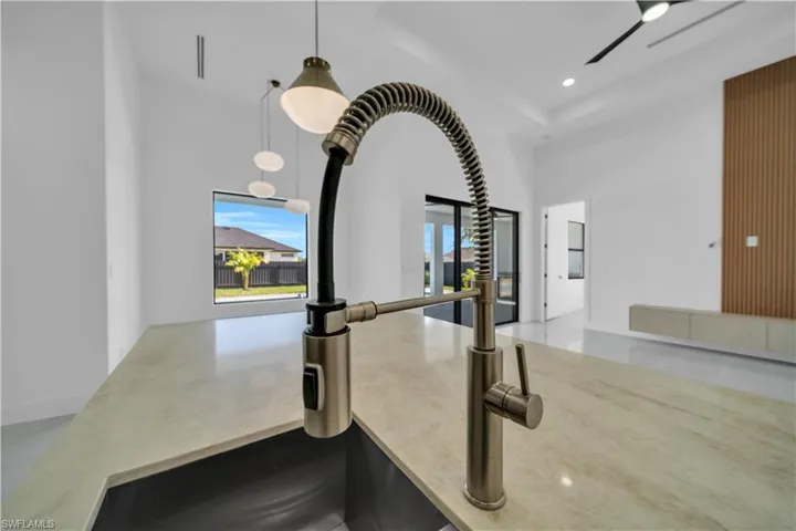 Kitchen view of hanging light fixtures, stone countertops, and recessed lighting