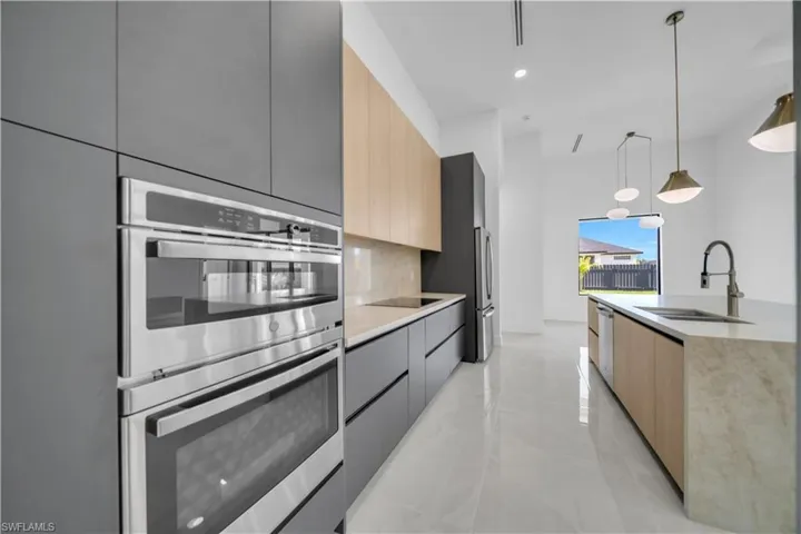 Kitchen featuring modern cabinets, appliances with stainless steel finishes, a sink, and recessed lighting