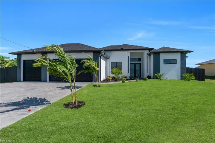 Prairie-style home with driveway, an attached garage, and stucco siding