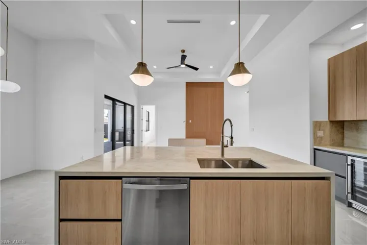 Kitchen featuring modern cabinets, dishwasher, a sink, recessed lighting, and light countertops