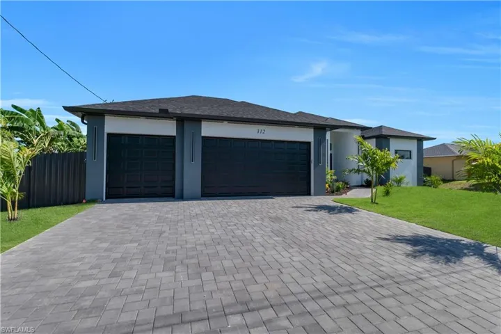 Prairie-style home with decorative driveway, a garage, and stucco siding
