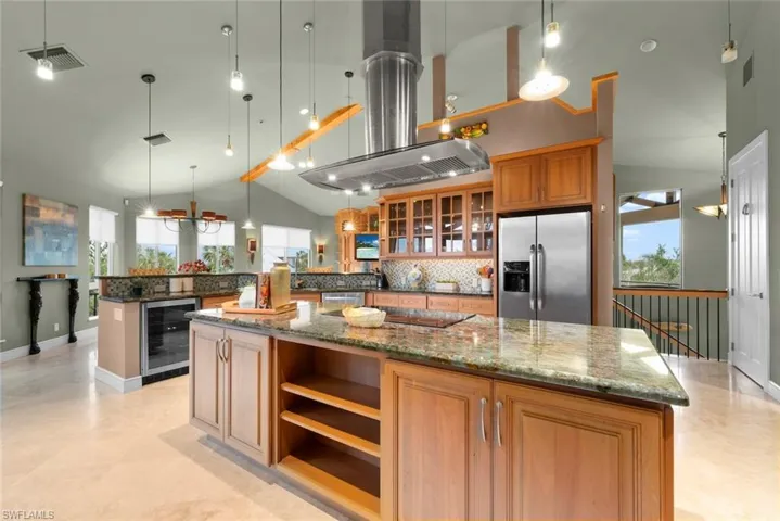 Kitchen featuring beverage cooler, stainless steel appliances, granite countertops, and pendant lighting