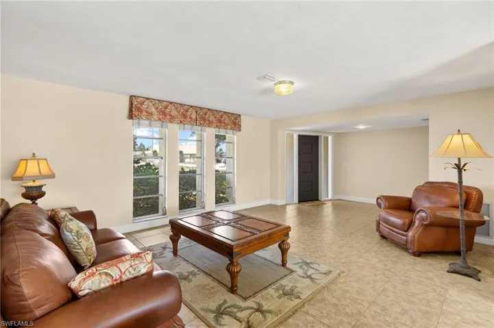 Living room with light tile patterned floors and baseboards