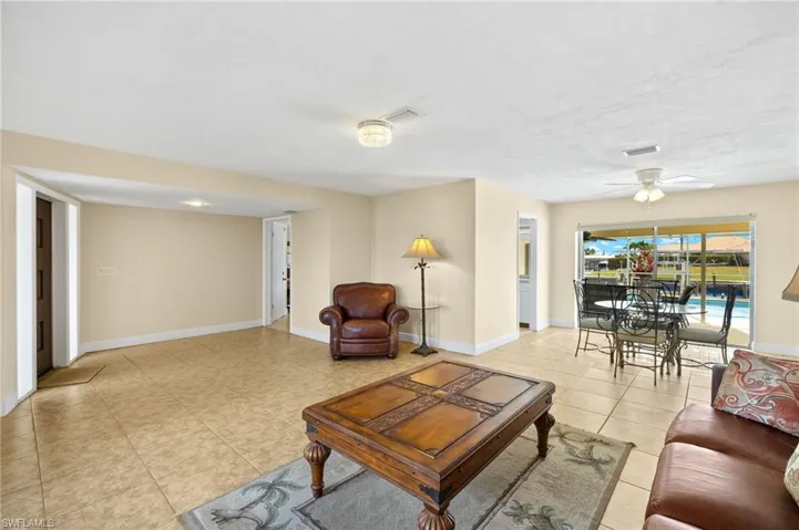 Living area with a ceiling fan and light tile patterned floors