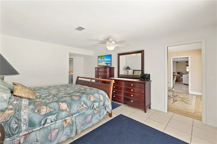 Bedroom with light tile patterned floors and a ceiling fan
