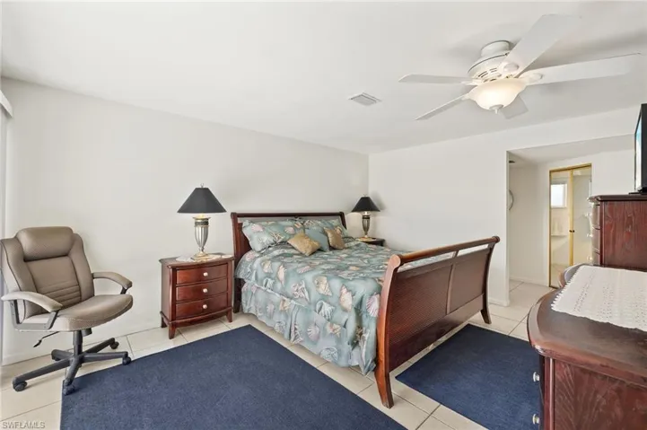 Bedroom with light tile patterned floors and a ceiling fan