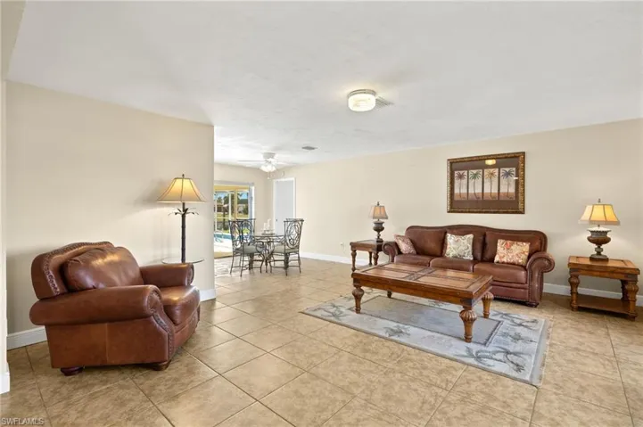 Living room with light tile patterned floors and ceiling fan