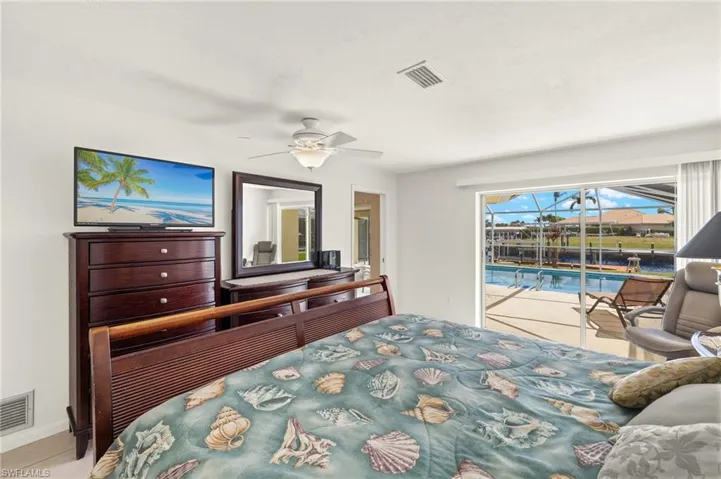 Bedroom with access to outside, a sunroom, and a ceiling fan