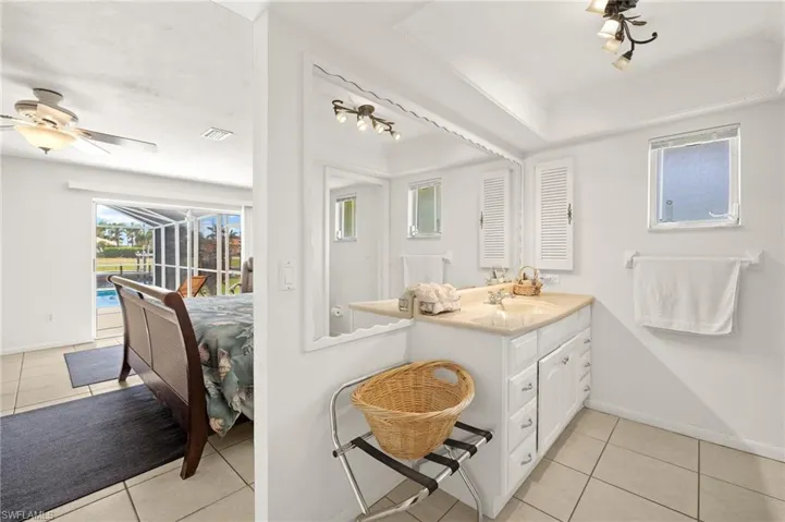 Bathroom with light tile patterned floors, vanity, and a ceiling fan