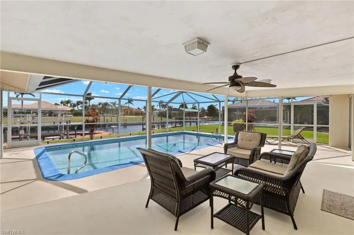 Swimming pool with a patio area, a lanai, a sunroom, and a water view