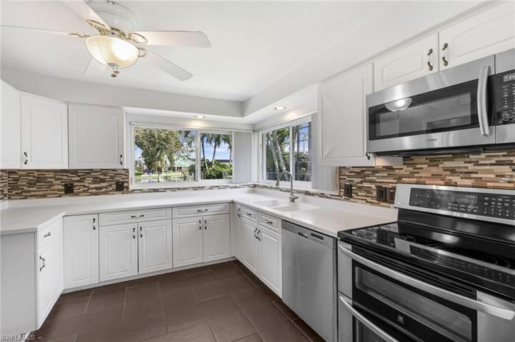 Stainless steel appliances, white cabinetry