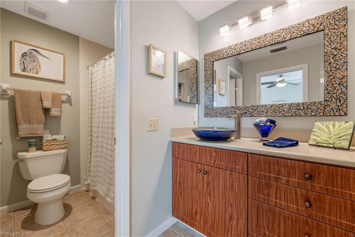 Full bath featuring light tile patterned flooring, vanity, and a shower with curtain