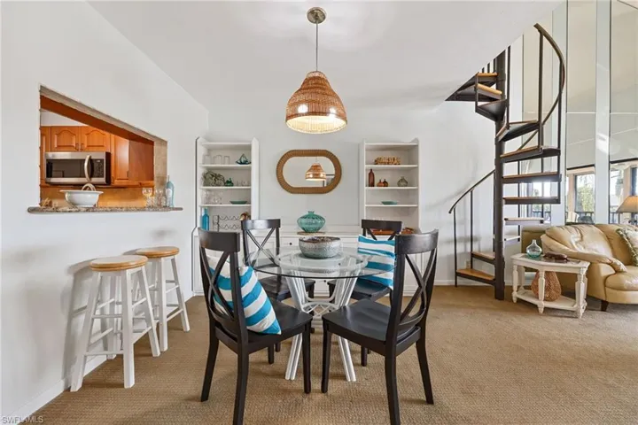 Dining room featuring light colored carpet and stairway