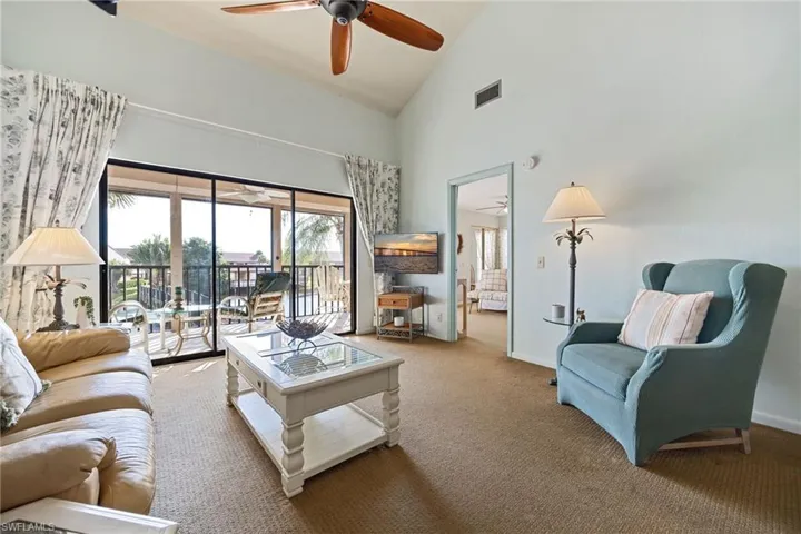 Carpeted living room with high vaulted ceiling and healthy amount of natural light