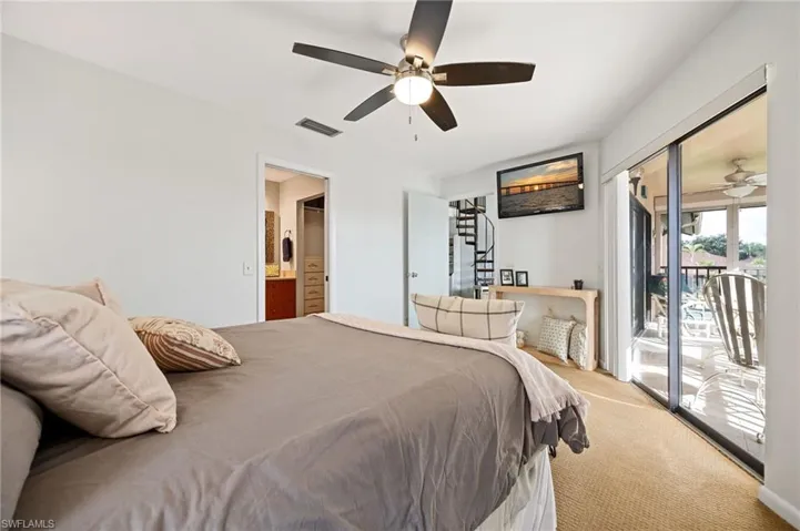 Carpeted bedroom with access to outside, ensuite bathroom, and ceiling fan