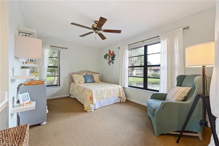 Carpeted bedroom with a ceiling fan and baseboards