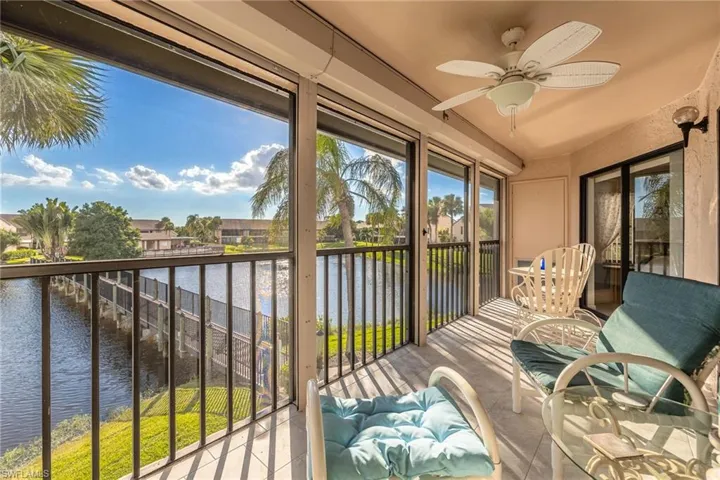 Sunroom / solarium featuring a balcony, a water view, and a ceiling fan