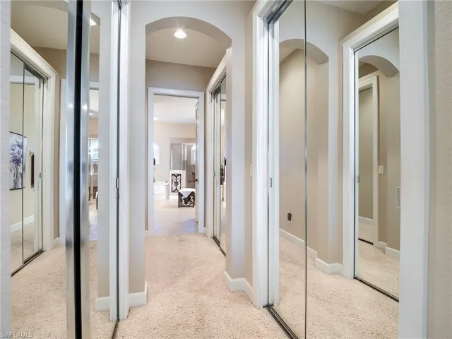 Primary hall to bath with closets on both sides
