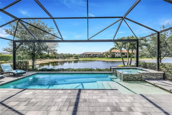 View of swimming pool featuring a lanai, an in ground hot tub, and a patio area