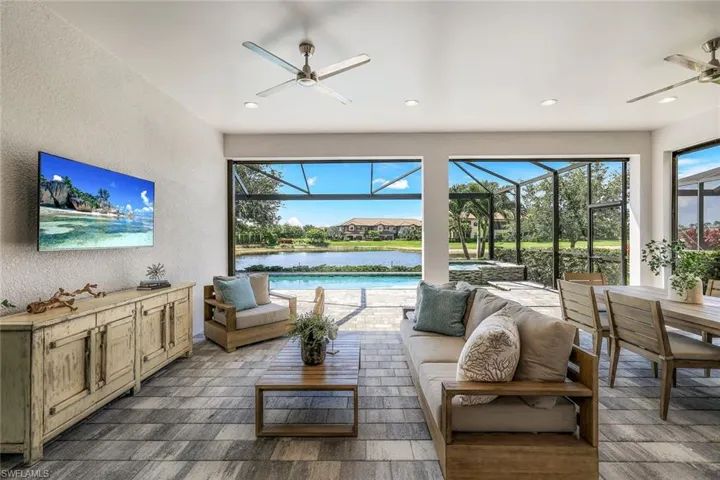 Living room featuring wood-type flooring, a water view, and ceiling fan
