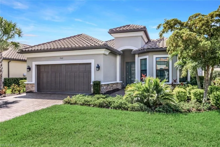 Mediterranean / spanish-style home featuring a front yard and a garage