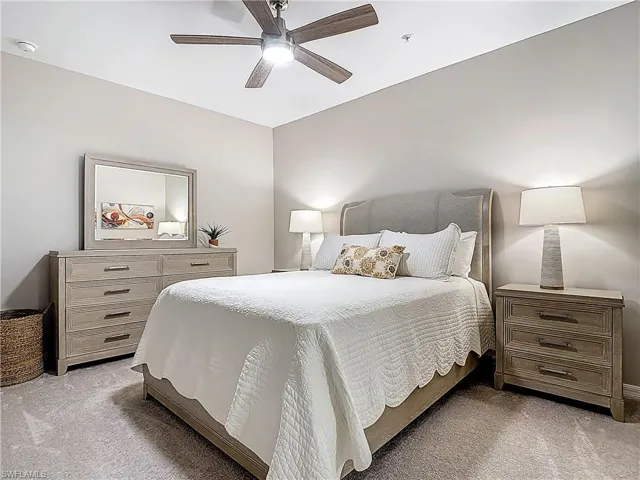 Bedroom with light colored carpet and a ceiling fan