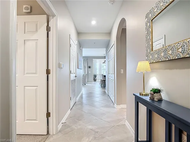 Corridor featuring arched walkways and baseboards