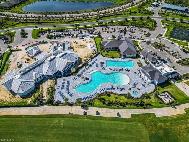 Aerial view of property and surrounding area featuring a pool and a nearby body of water