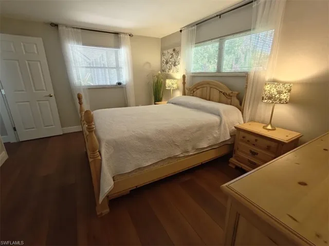 Bedroom with dark hardwood / wood-style flooring