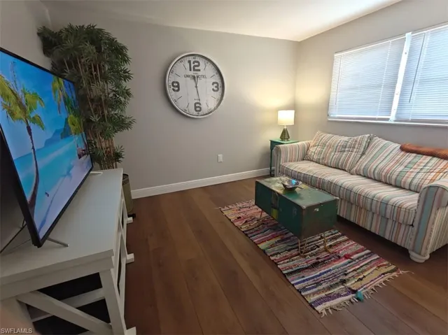 Living room with dark hardwood / wood-style flooring