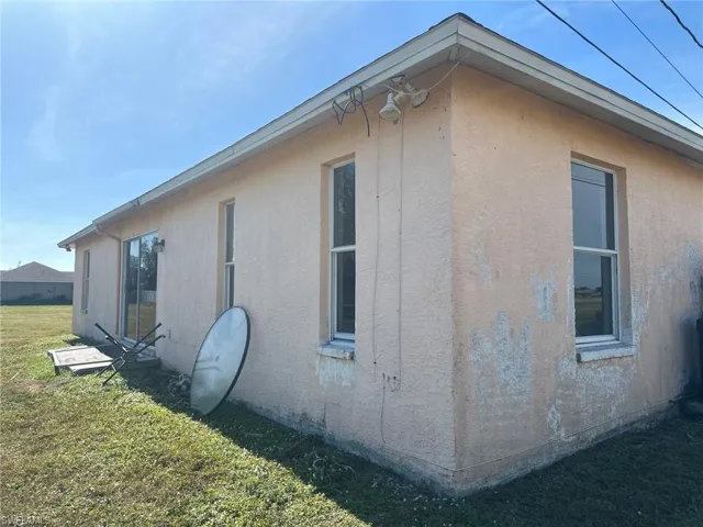 View of property exterior with a yard