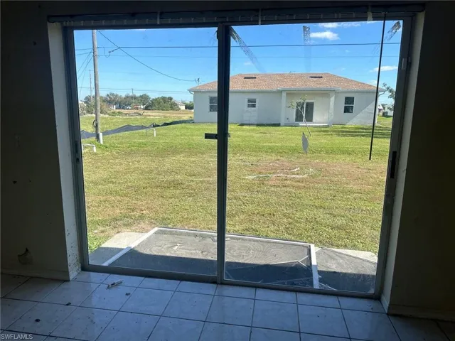 Doorway featuring light tile patterned flooring