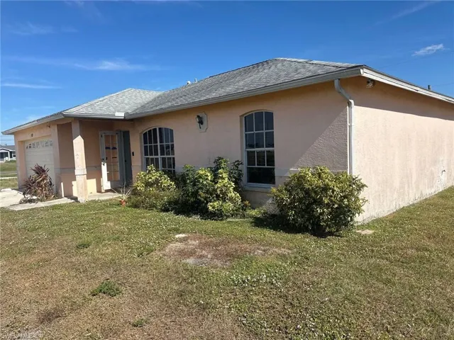 Rear view of house with a yard and a garage