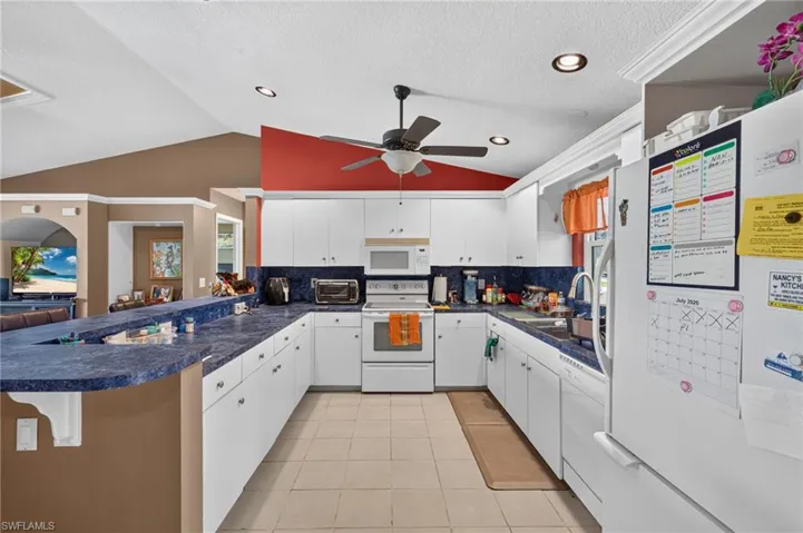 Kitchen featuring white cabinetry, blue countertops, recessed lighting, and tile flooring