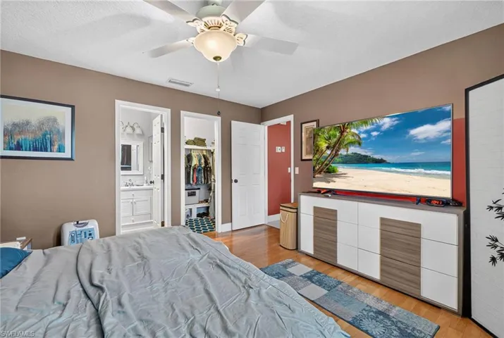 Primary bedroom featuring walk in closet and en suite bathroom.