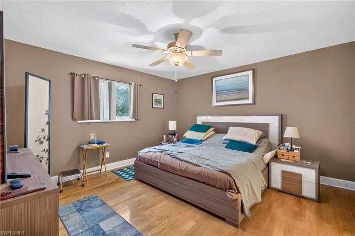 Large primary bedroom featuring vinyl flooring, a ceiling fan with integrated lighting,