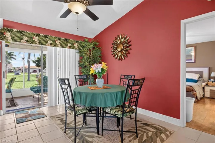 Tiled flooring throughout this dining space features a ceiling fan, direct access to the enclosed patio via sliding glass doors.