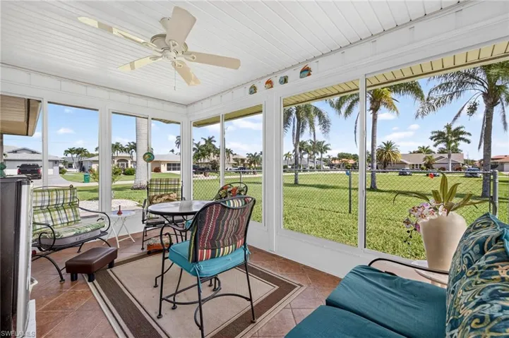 Enclosed patio featuring white framed windows, a white paneled ceiling with a ceiling fan, and tile flooring