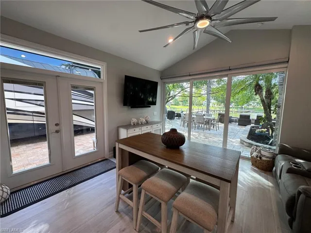 Dining area featuring lofted ceiling, ceiling fan, light wood-type flooring, and french doors