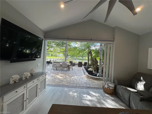 Living room with lofted ceiling and light hardwood / wood-style floors